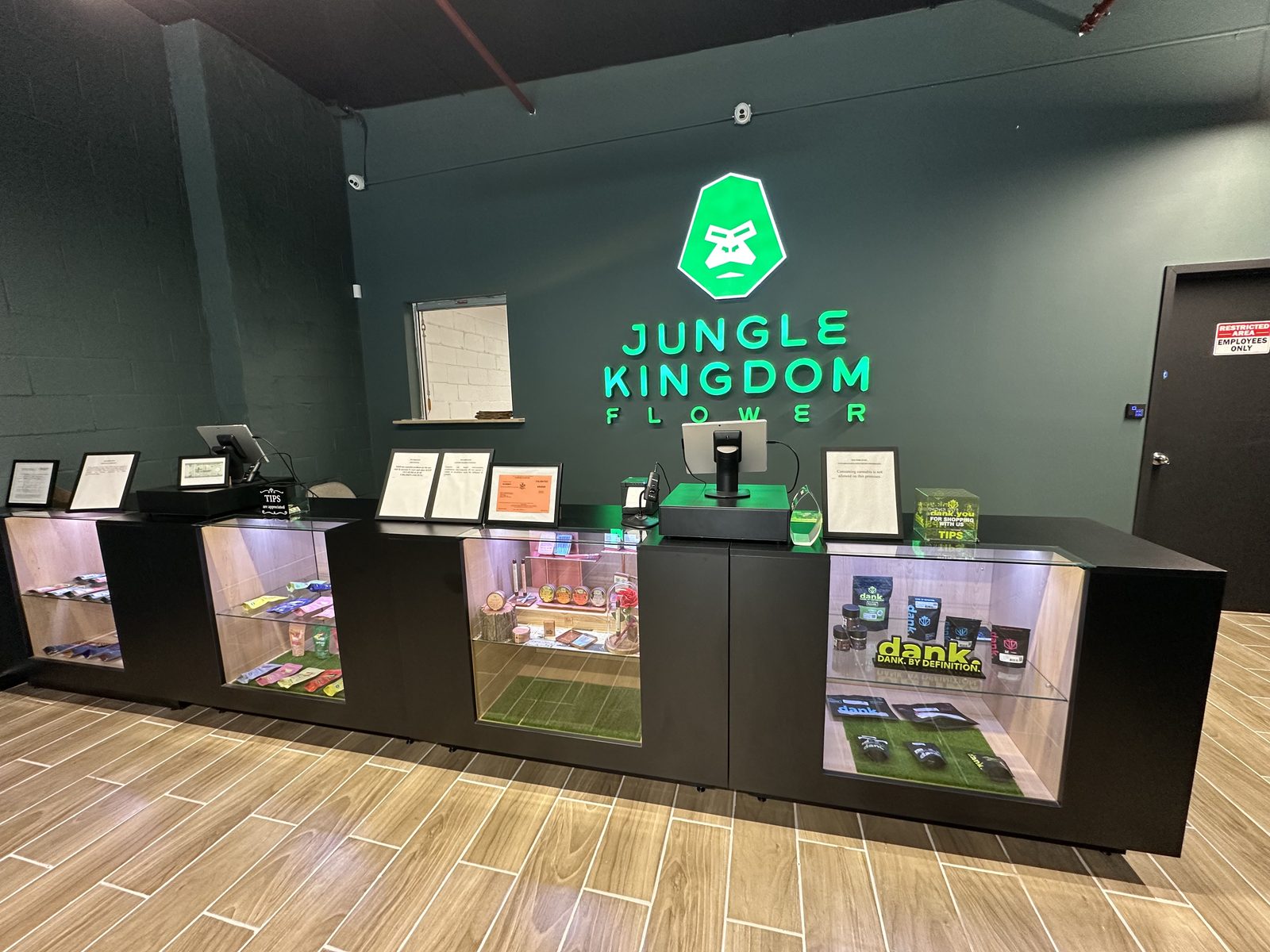 Checkout counter with illuminated display cases and neon Jungle Kingdom Flower sign