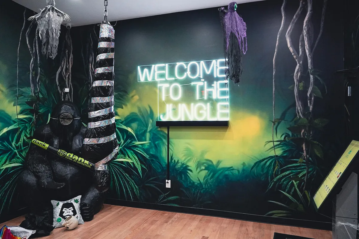 Welcome to the Jungle neon sign over a jungle mural inside the Bed-Stuy store